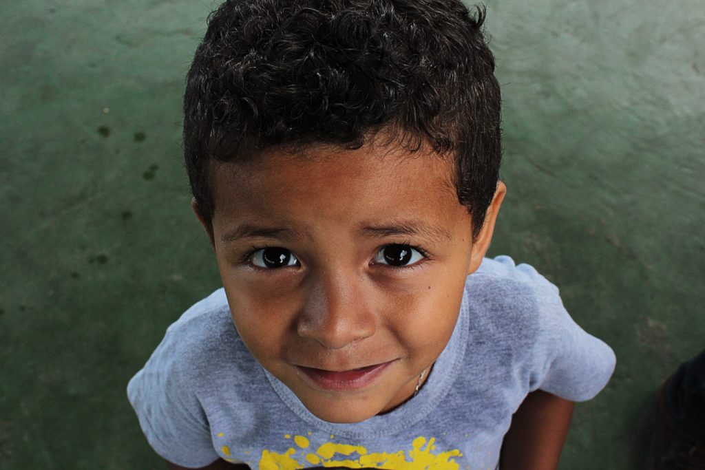 A photo of a young boy. He is looking up at the camera.